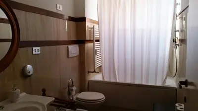 a bathroom with a toilet and a tub and a sink at Vatican Suites Happy Holidays in Rome