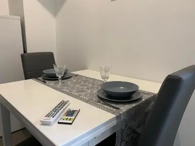 a table with two bowls and a remote control on it at A casa di Elly in Rome