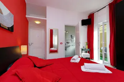 a red bedroom with a red bed and a bathroom at I Pini di Roma - Rooms & Suites in Rome