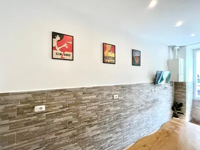 a room with a brick wall with three pictures on the wall at I Pini di Roma - Rooms & Suites in Rome