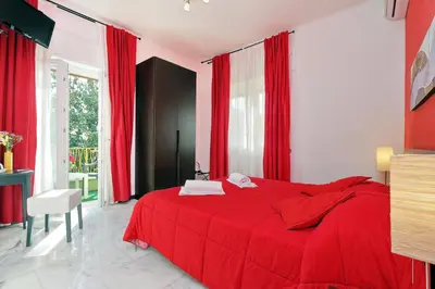 a red bed in a room with red curtains at I Pini di Roma - Rooms & Suites in Rome