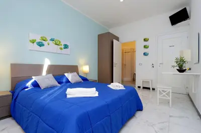 a large blue bed in a white room at I Pini di Roma - Rooms & Suites in Rome