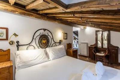 a bedroom with a white bed and a wooden ceiling at Gambero Apartments in Rome