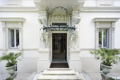 a white building with a doorway with two plants at Villa Laetitia in Rome