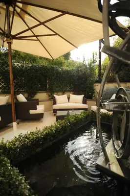 a patio with a koi pond and an umbrella at Hotel Villa Duse in Rome