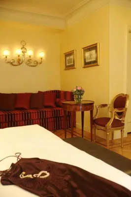 a bedroom with a bed and a couch and a table at Hotel Villa Duse in Rome