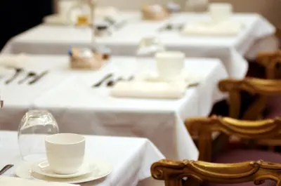 a table with white tables with white cups and chairs at Hotel Villa Duse in Rome