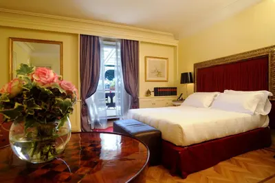 a bedroom with a bed and a table with a vase of flowers at Hotel Villa Duse in Rome