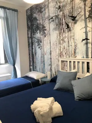 two beds in a room with birds on the wall at giolitti central room in Rome