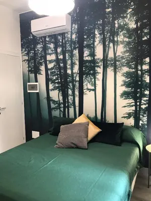 a bedroom with a green bed with trees on the wall at giolitti central room in Rome