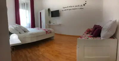 a bedroom with a bed and a tv on the wall at Orchids Apartment in Rome