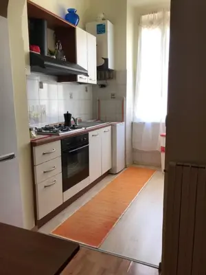 a kitchen with white cabinets and a stove at Orchids Apartment in Rome