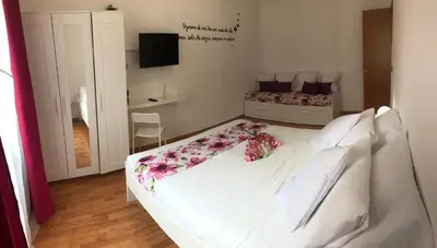 a bedroom with a white bed with flowers on it at Orchids Apartment in Rome