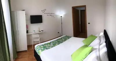 a bedroom with a white bed with green pillows at Orchids Apartment in Rome