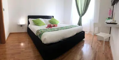 a bedroom with a large bed with green pillows at Orchids Apartment in Rome