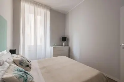 a white bedroom with a bed and a window at La Dimora del Cardinale in Rome