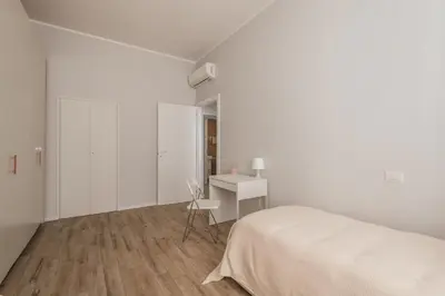 a white bedroom with a bed and a desk at La Dimora del Cardinale in Rome