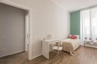 a white bedroom with a bed and a desk at La Dimora del Cardinale in Rome