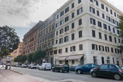 a large white building with cars parked on a street at La Dimora del Cardinale in Rome