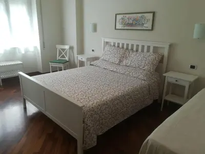 a bedroom with a white bed and two tables at Anton Inn Rome Cornelia Apartment in Rome
