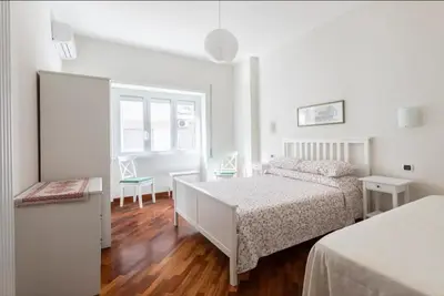 a white bedroom with a bed and a desk at Anton Inn Rome Cornelia Apartment in Rome
