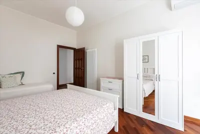 a white bedroom with a bed and a mirror at Anton Inn Rome Cornelia Apartment in Rome