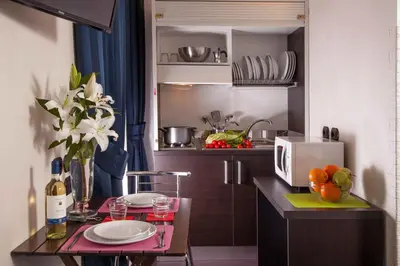 a kitchen with a table with plates and a microwave at Residenza Dorò- 24x7 Check-in in Rome