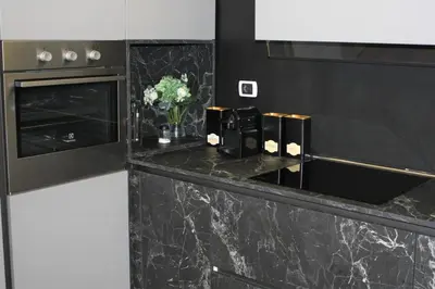 a kitchen with a black counter top with flowers on it at Domus Caecilia - via Cola di Rienzo in Rome