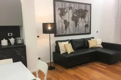 a living room with a black couch and a table at Domus Caecilia - via Cola di Rienzo in Rome