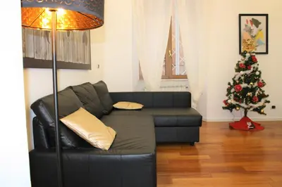a black leather couch in a living room with a christmas tree at Domus Caecilia - via Cola di Rienzo in Rome
