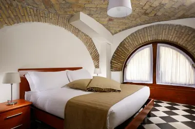 a bedroom with a large bed with a brick wall at Roma Resort Termini in Rome