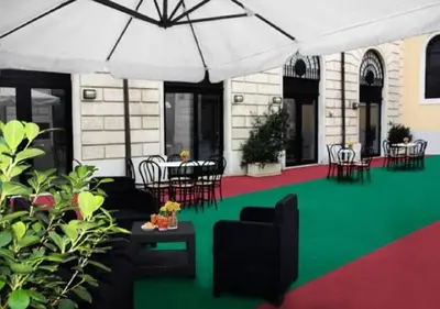 a rendering of a patio with chairs and an umbrella at Roma Resort Termini in Rome