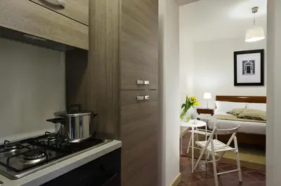 a kitchen with a stove and a bedroom with a bed at Roma Resort Termini in Rome