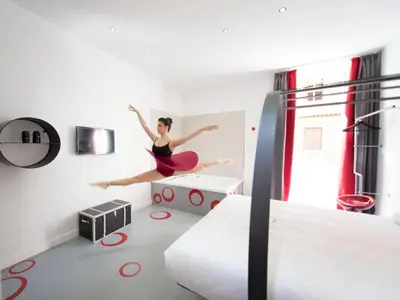 a woman jumping on a bed in a bedroom at 7 Inn Spanish Steps in Rome