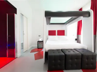 a bedroom with a bed with a black ottoman at 7 Inn Spanish Steps in Rome