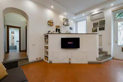 a living room with a tv on a white wall at Roman Forum Apartment - The Heart of Rome in Rome