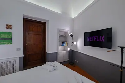 a room with two beds and a tv on the wall at Roman Forum Apartment - The Heart of Rome in Rome