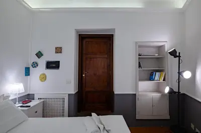 a room with a bed and a wooden door at Roman Forum Apartment - The Heart of Rome in Rome