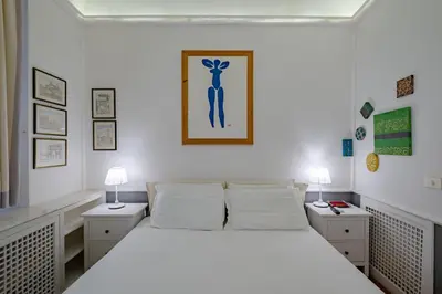 a bedroom with a large white bed with two night stands at Roman Forum Apartment - The Heart of Rome in Rome