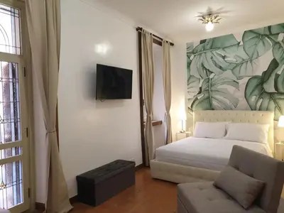 a bedroom with a bed and a tv and a couch at Colosseo Smart Flat in Rome