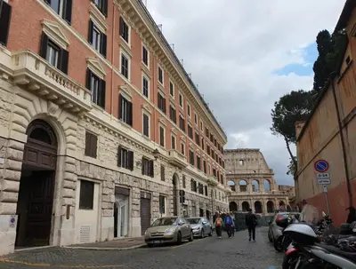 a group of people walking down a street next to buildings at Colosseo Smart Flat in Rome