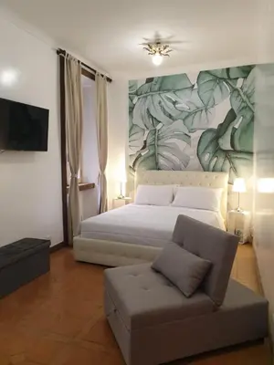 a bedroom with a bed and a couch and a mural at Colosseo Smart Flat in Rome