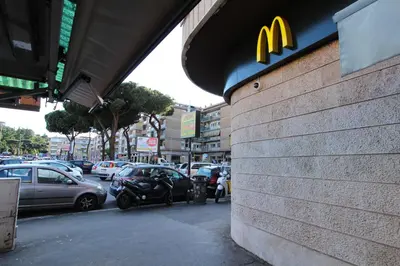 a mcdonalds restaurant with cars parked in a parking lot at Star of Rome in Rome