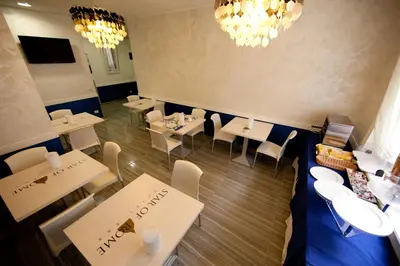 a restaurant with white tables and chairs and chandeliers at Star of Rome in Rome