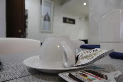 a white cup on a plate on a table at Star of Rome in Rome