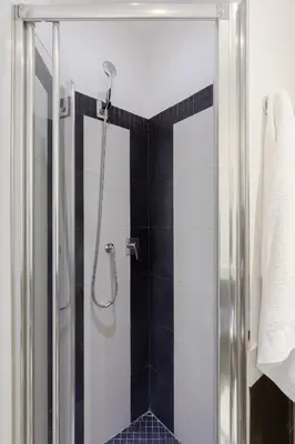 a bathroom with a shower with a black and white tiles at Relais Roma Centro in Rome