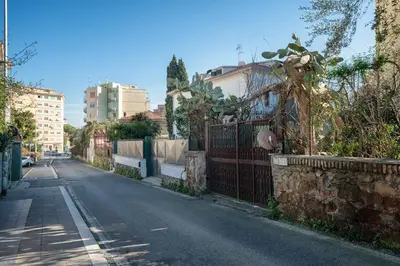 an empty street with a fence and some buildings at Vic Pigneto, Luxury House Terrace Roma in Rome