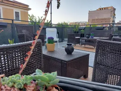 a patio with chairs and a table with a vase on it at Vic Pigneto, Luxury House Terrace Roma in Rome
