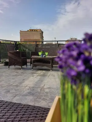 a patio with chairs and a table and purple flowers at Vic Pigneto, Luxury House Terrace Roma in Rome