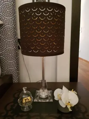 a lamp on a table with a candle and flowers at Vic Colosseo, Centro Storico Roma in Rome